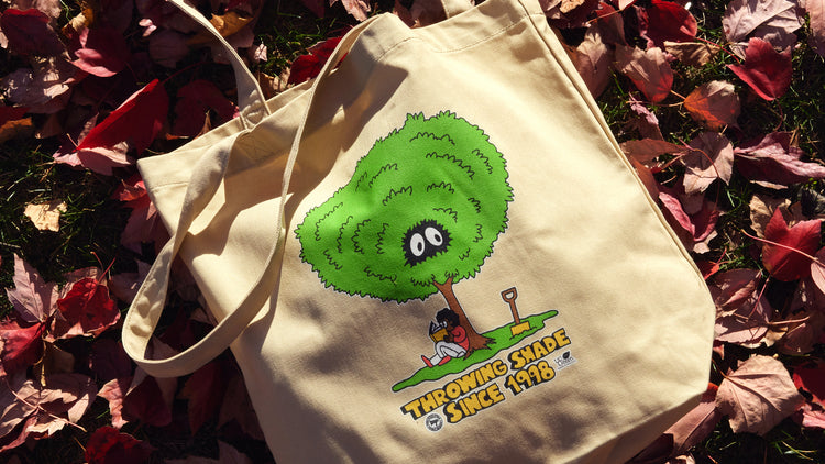 Throwing shade tote lying on a bed of red and brown leaves