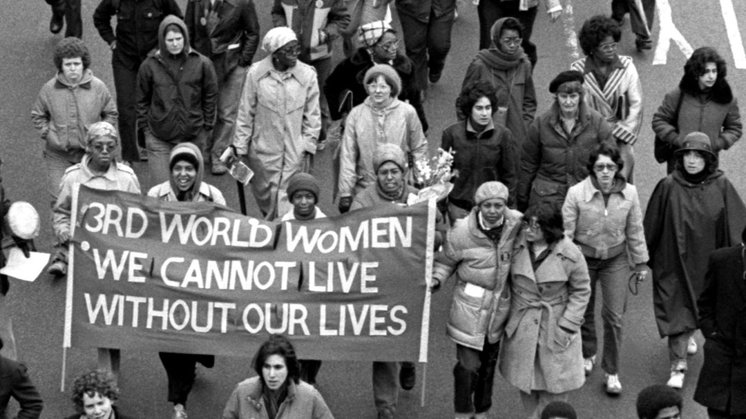 Black and white photo of the combahee river collective marching in a protest. a banner reads "3rd world women we can not live without our lives"